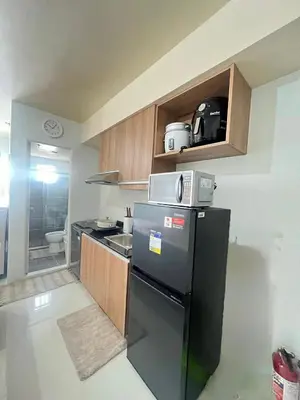 a kitchen with a black refrigerator and a sink at Paradise Room in Las Piñas City in Manila
