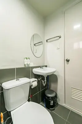 a bathroom with a white toilet and a sink at Paradise Room in Las Piñas City in Manila