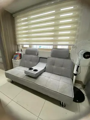 a couch in a living room with a fan at Coast Residences by Casa Stellar in Manila
