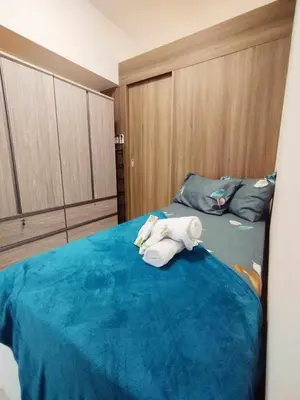 a stuffed animal laying on a bed in a room at Coast Residences by Casa Stellar in Manila