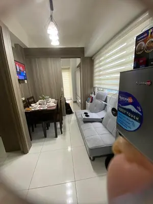 a person taking a picture of a living room at Coast Residences by Casa Stellar in Manila