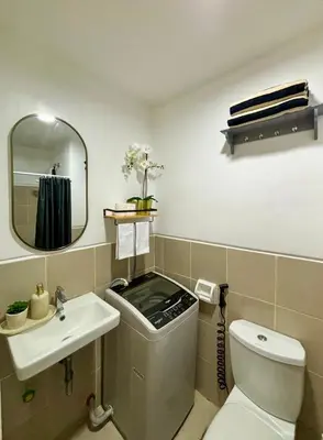 a bathroom with a toilet and a sink and a mirror at Cozy and Homey 1BR Condo at SMDC South Residences in Manila