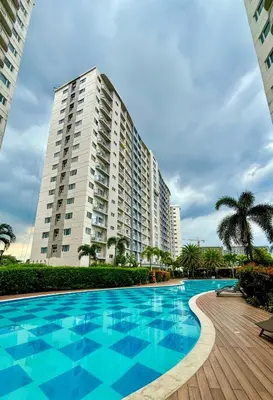 a large apartment building with a large swimming pool at Cozy and Homey 1BR Condo at SMDC South Residences in Manila