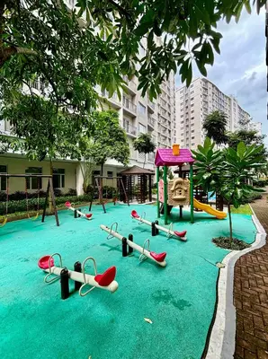 a playground with slides and a play set on a pool of water at Cozy and Homey 1BR Condo at SMDC South Residences in Manila