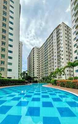 a large swimming pool in front of two tall buildings at Cozy and Homey 1BR Condo at SMDC South Residences in Manila
