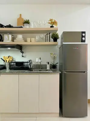 a kitchen with a stainless steel refrigerator at Cozy and Homey 1BR Condo at SMDC South Residences in Manila
