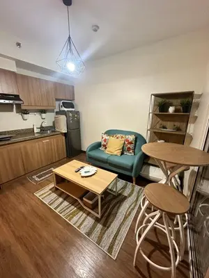a living room with a couch and a table at Prisma Residences Astra Building in Manila