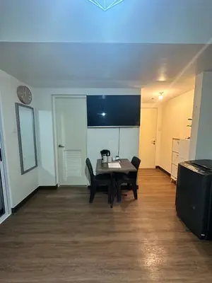 a dining room with a table and chairs at Prisma Residences Astra Building in Manila