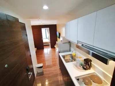 a kitchen with white cabinets and a counter top at Air Residence 1BR Condo with City View in Manila