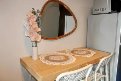 a table with a vase of flowers and a mirror at Air Residence 1BR Condo with City View in Manila