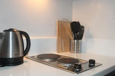 a tea kettle and utensils on a kitchen counter at Air Residence 1BR Condo with City View in Manila