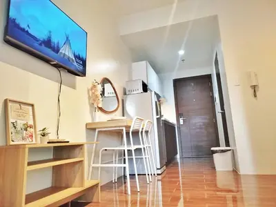 a living room with a flat screen tv on the wall at Air Residence 1BR Condo with City View in Manila