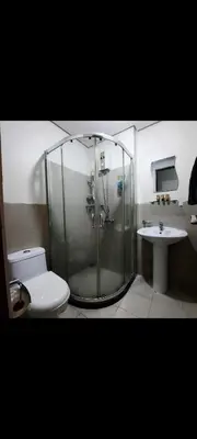 a bathroom with a shower and a toilet and a sink at THE BEACON Aparthotels in Manila