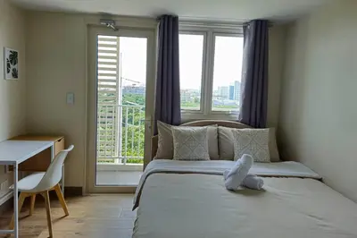a bedroom with a bed with a teddy bear on it at Modern & New, Work Desk, Fast Internet, Balcony in Manila