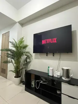 a tv on a wall with a netflix sign on it at Entire unit with balcony at SMDC Field Residences, behind Sucat near NAIA in Manila