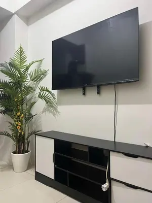 a flat screen tv on a wall in a living room at Entire unit with balcony at SMDC Field Residences, behind Sucat near NAIA in Manila