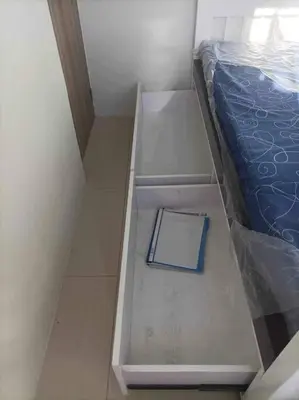 a bed with a book sitting on top of it at Entire unit with balcony at SMDC Field Residences, behind Sucat near NAIA in Manila