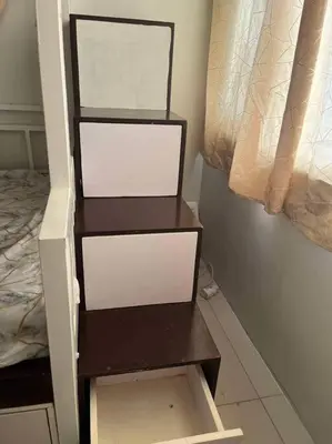 a shelf with three drawers in a bedroom at Entire unit with balcony at SMDC Field Residences, behind Sucat near NAIA in Manila