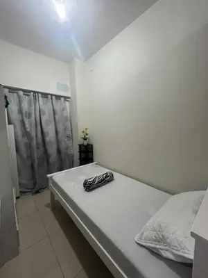 a white bed in a room with a window at Entire unit with balcony at SMDC Field Residences, behind Sucat near NAIA in Manila