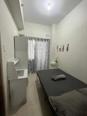 a bedroom with a bed and a desk and a window at Chill in Peace Staycation 2BR condo at Field Residences, Sucat near NAIA in Manila