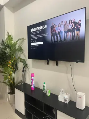 a flat screen tv hanging on a wall at Chill in Peace Staycation 2BR condo at Field Residences, Sucat near NAIA in Manila
