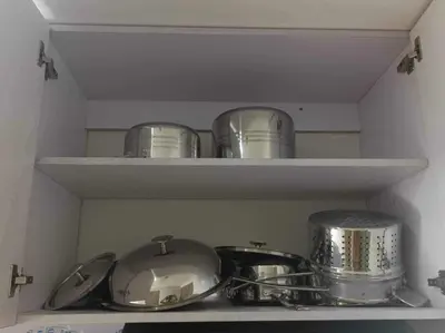 a kitchen shelf with pots and pans on it at Chill in Peace Staycation 2BR condo at Field Residences, Sucat near NAIA in Manila