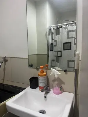 a bathroom with a sink and a mirror at Chill in Peace Staycation 2BR condo at Field Residences, Sucat near NAIA in Manila