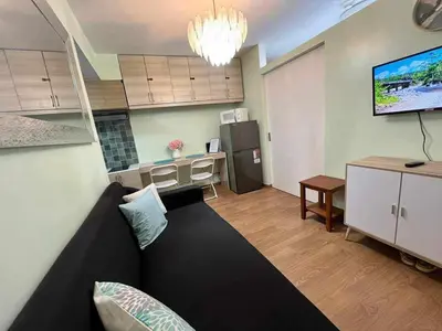 a living room with a couch and a kitchen at Comfy Relax Condo at the Rise Makati in Manila