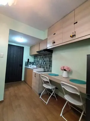 a kitchen with a table and chairs in a room at Comfy Relax Condo at the Rise Makati in Manila