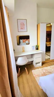 a bedroom with a desk with a bed and a mirror at Bigg Apol Suite in Manila