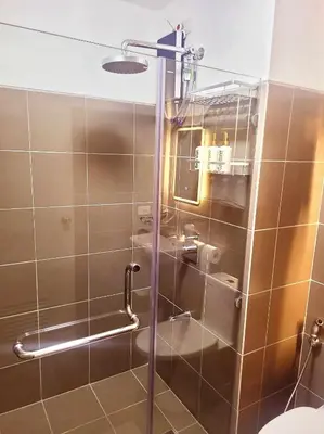 a shower with a glass door in a bathroom at Bigg Apol Suite in Manila