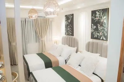 two beds in a room with white walls at Becca Suite by Crib2GO with Pool View in Manila