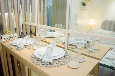 a table with white plates and glasses on it at Becca Suite by Crib2GO with Pool View in Manila