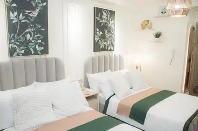 two beds sitting next to each other in a bedroom at Becca Suite by Crib2GO with Pool View in Manila