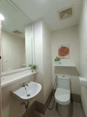 a white bathroom with a toilet and a sink at Vista GL Taft Studio Unit in Manila