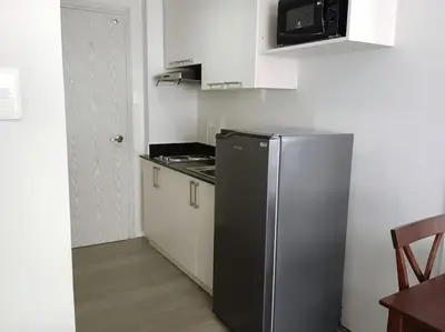 a small kitchen with a refrigerator and a microwave at Vista GL Taft Studio Unit in Manila