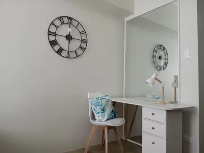 a room with a desk and a clock on the wall at Vista GL Taft Studio Unit in Manila