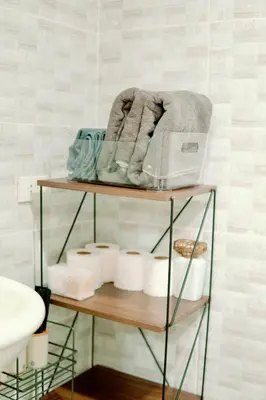 a bathroom with a shelf with towels and toiletries at Spacious 2BR at SoMa BGC Near SM Aura and Bonifacio High Street in Manila