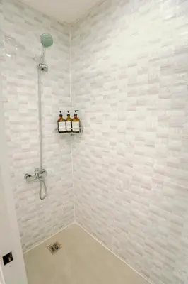 a bathroom with a shower with two bottles of alcohol at Spacious 2BR at SoMa BGC Near SM Aura and Bonifacio High Street in Manila