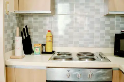 a kitchen counter with a stove top in a kitchen at Spacious 2BR at SoMa BGC Near SM Aura and Bonifacio High Street in Manila