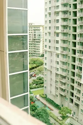 two tall buildings are seen from a window at Spacious 2BR at SoMa BGC Near SM Aura and Bonifacio High Street in Manila