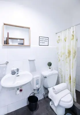 a bathroom with a sink and a toilet and a mirror at Homey and Cozey Poblacion Makati S01 in Manila