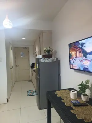 a kitchen with a refrigerator and a table in a room at SEA RESIDENCES NEAR MALL OF ASIA BY Amigo's place in Manila