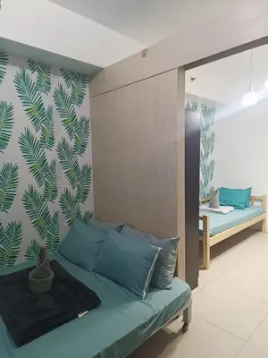 a bedroom with a couch and a wall with a mural at SEA RESIDENCES NEAR MALL OF ASIA BY Amigo's place in Manila