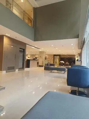 a large lobby with blue chairs and a living room at SEA RESIDENCES NEAR MALL OF ASIA BY Amigo's place in Manila