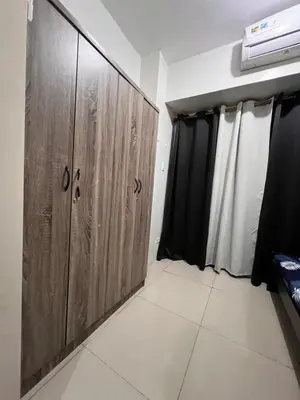 a room with wooden cabinets in a room at Sea Residences MOA Manila By Paul XIVI in Manila