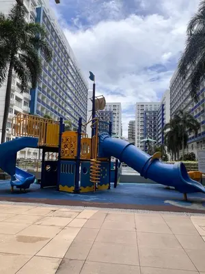 a blue slide in a playground in a city at Sea Residences MOA Manila By Paul XIVI in Manila