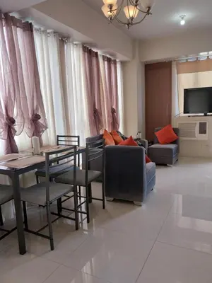 a living room with a couch and a table at Emy Cozy Studio unit with street view balcony in Manila