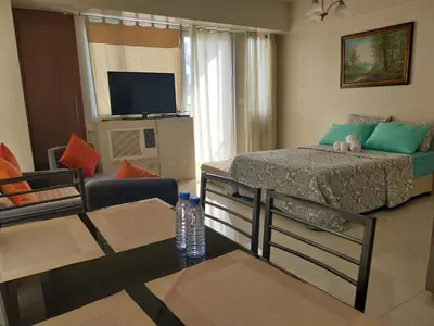 a small living room with a bed and a couch at Emy Cozy Studio unit with street view balcony in Manila