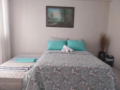 a bedroom with a bed with a stuffed animal on it at Emy Cozy Studio unit with street view balcony in Manila